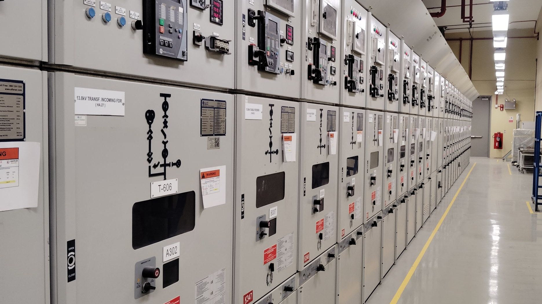 Row of electrical switchgear cabinets lining an industrial control room